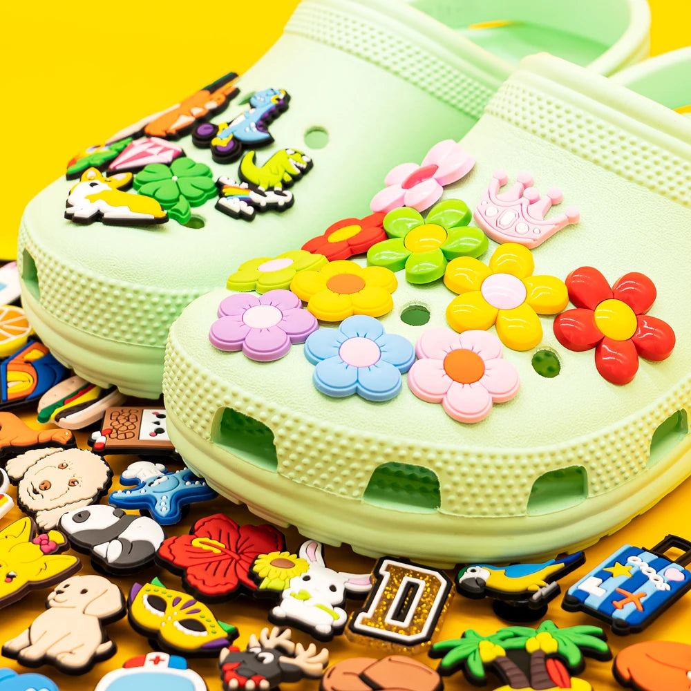 Green clog shoe with colorful decorative charms on a yellow background