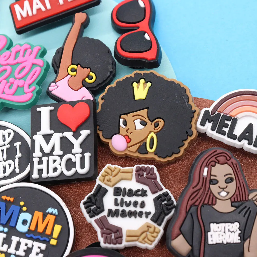 Collection of colorful charms with various designs and text on a textured surface.