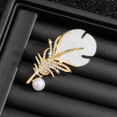 Gold and pearl brooch on a black textured surface