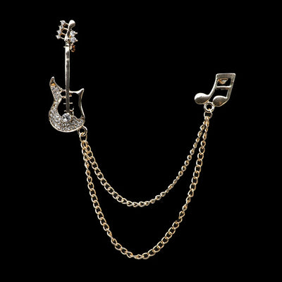 Silver brooch with guitar and music note design on a black background