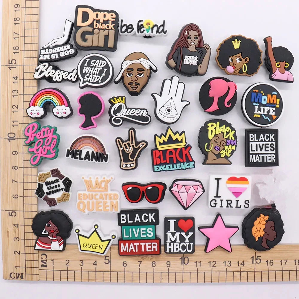 Collection of colorful charms with various designs on a ruler for scale.