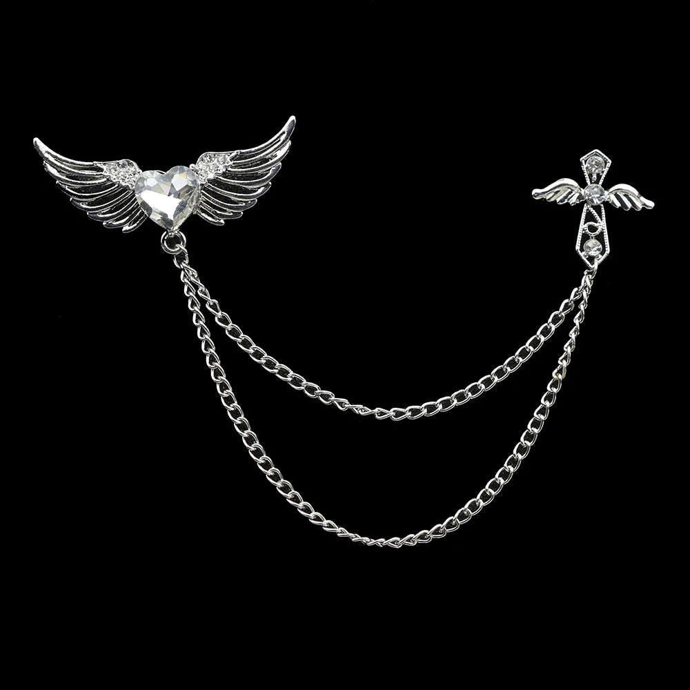 Silver brooch with wings and chain on a black background