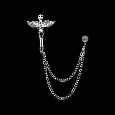 Silver brooch with chain on a black background