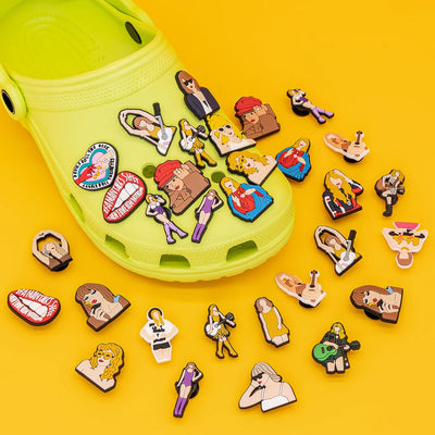 Yellow clog shoe with various decorative pins on a yellow background
