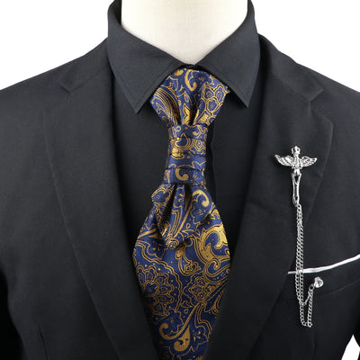 Black suit with a blue and gold paisley tie and a decorative lapel pin on a mannequin.