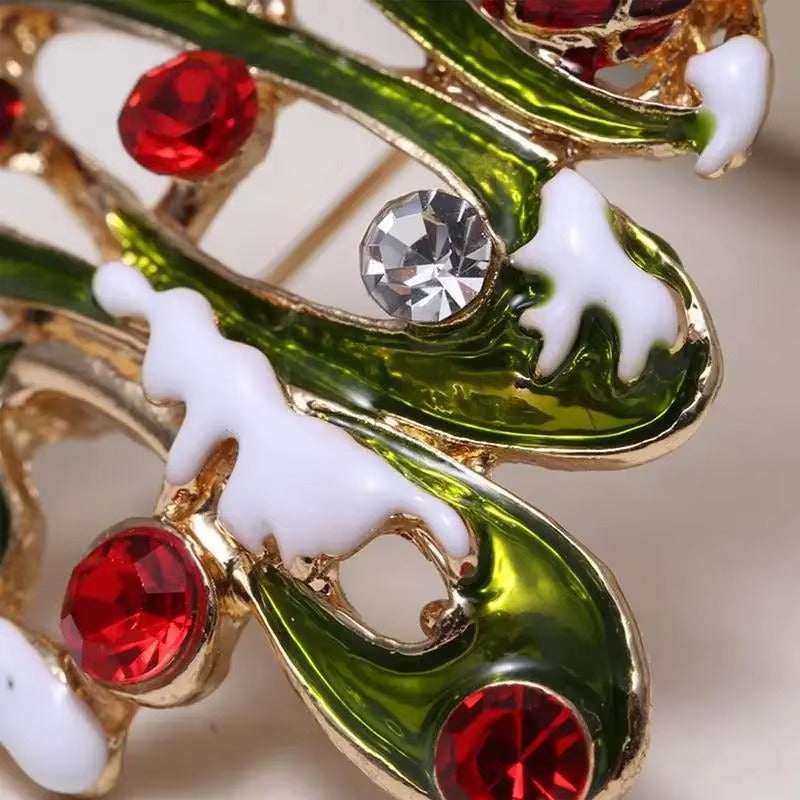 Close-up of decorative brooch with green, red, and gold colors on a light background