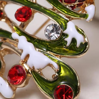Close-up of decorative brooch with green, red, and gold colors on a light background
