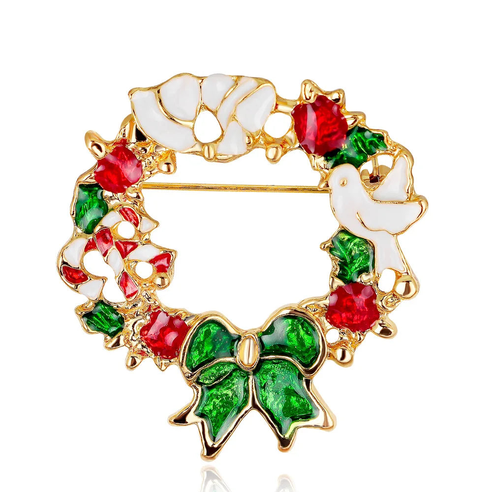 Christmas-themed brooch with gold frame, red berries, green leaves, and white dove on a white background