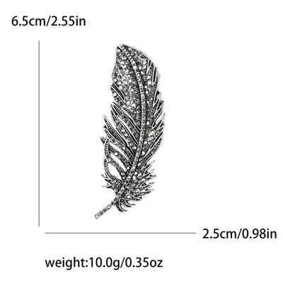 Feather-shaped brooch with measurements and weight details on a white background