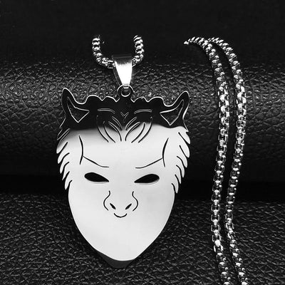 Silver mask pendant necklace on a black textured background