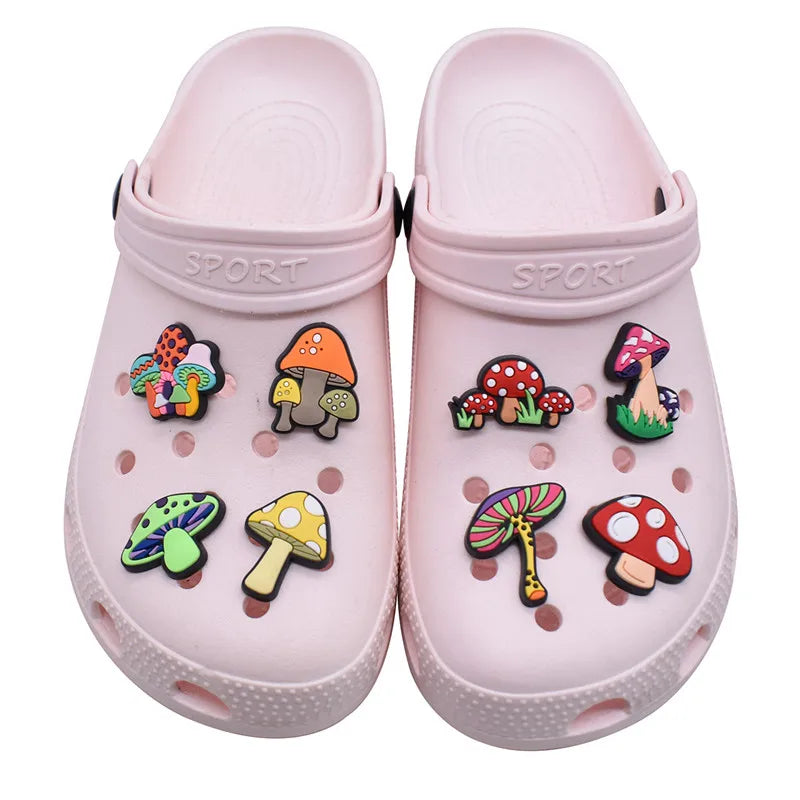 Pink clogs with colorful mushroom-shaped charms on a white background