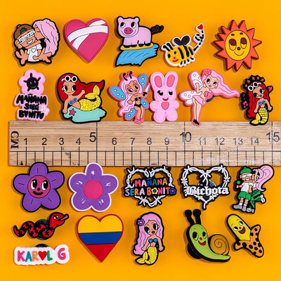Collection of colorful cartoon-style shoe charms on a yellow background with a ruler for scale.