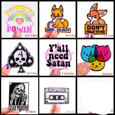 Collection of various patches with different designs and text, held by hands.
