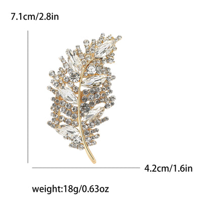 Gold and crystal leaf-shaped brooch with measurements and weight displayed.