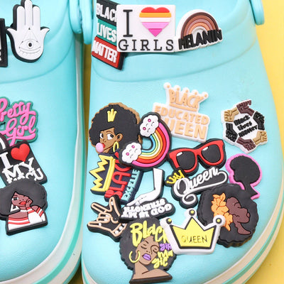 Light blue shoes with various colorful charms and graphics on a yellow background