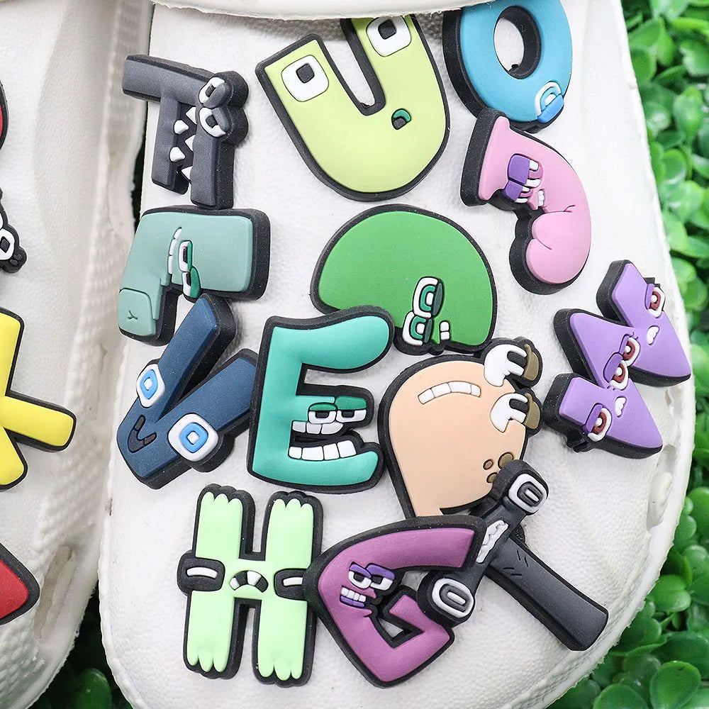 Colorful shoe charms with cartoon characters and text on a white background