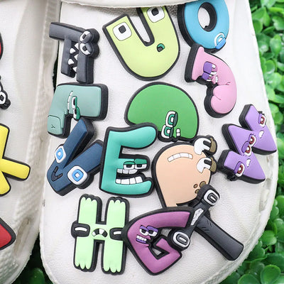 Colorful shoe charms with cartoon characters and text on a white background