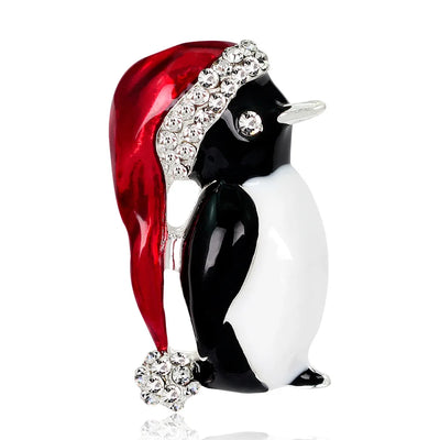 Penguin figurine wearing a red Santa hat with rhinestones on a white background
