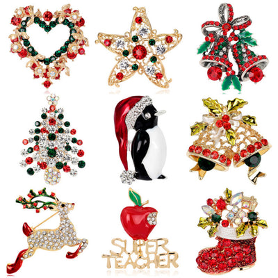 Collection of Christmas-themed brooches including a star, wreath, penguin, tree, bell, deer, apple, and 'Super Teacher' design.