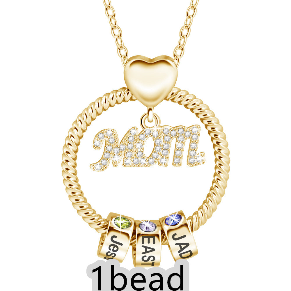 Gold necklace with 'Mom' pendant and three small square charms on a white background 1 bead