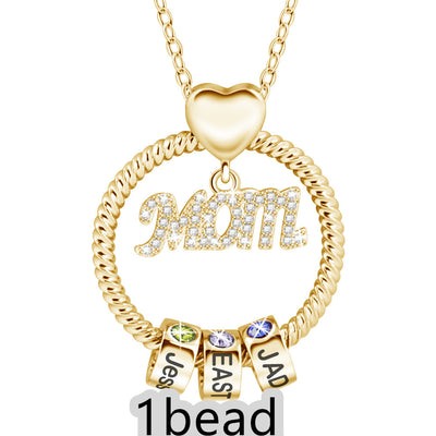 Gold necklace with 'Mom' pendant and three small square charms on a white background 1 bead