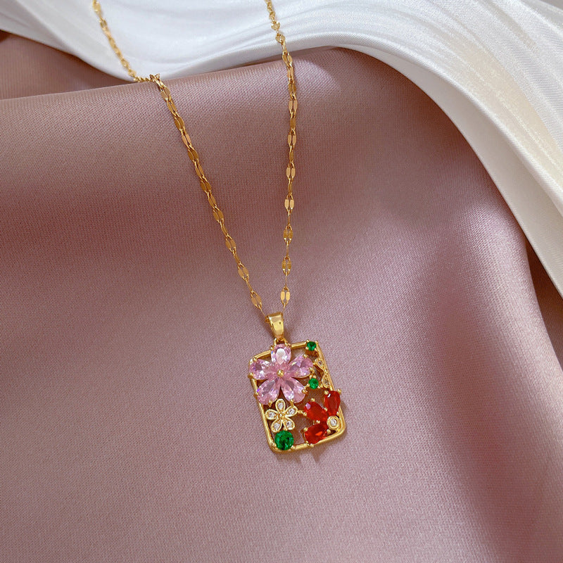 Gold necklace with a colorful pendant on a pink fabric background