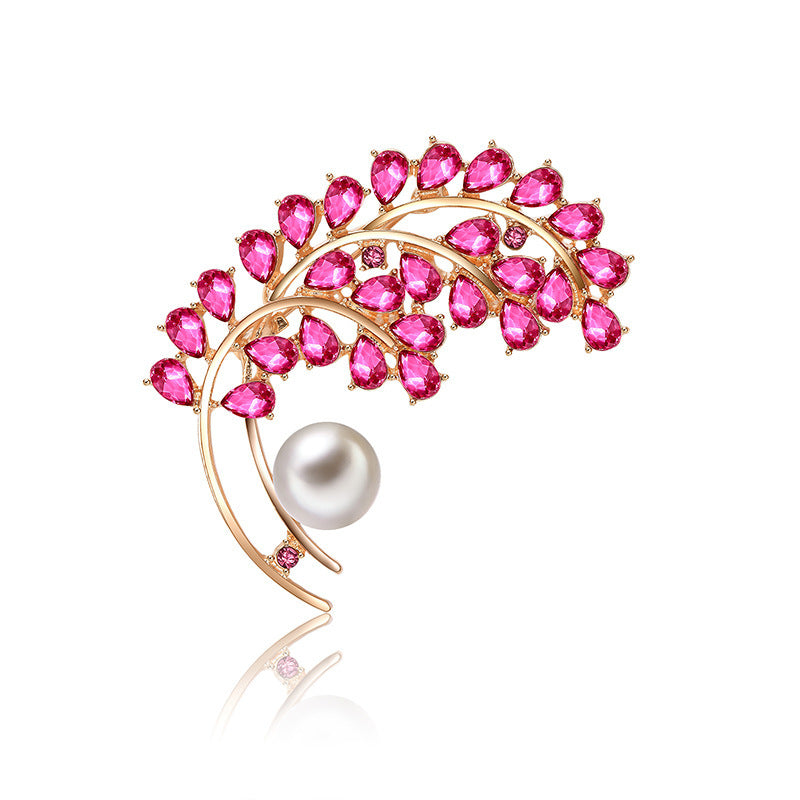 Jewelry brooch with pink gemstones and a pearl on a white background