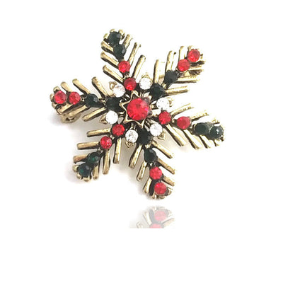 Gold cross-shaped brooch with red and black gemstones on a white background
