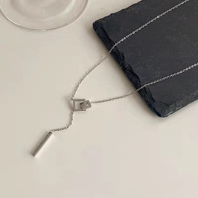 Silver necklace with a pendant on a white surface