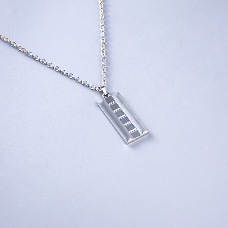 Silver necklace with a rectangular pendant on a light gray background