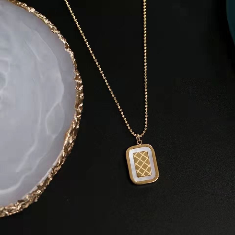 Gold necklace with a pendant on a dark surface