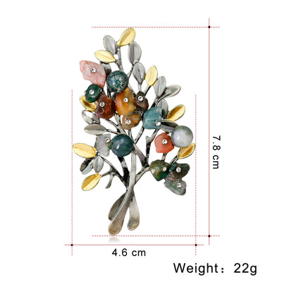 Multicolored brooch with leaf design and measurements on a white background