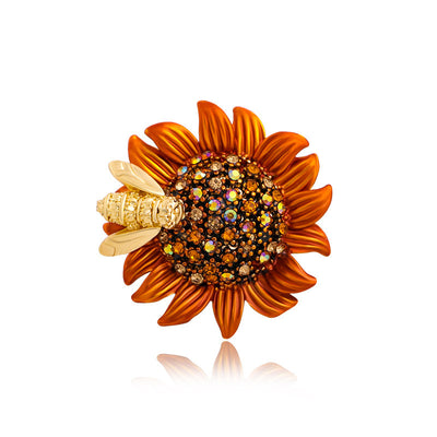 Sunflower-shaped brooch with gemstones and a bee on a white background