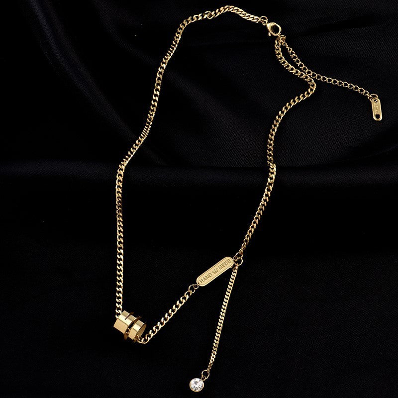 Gold chain necklace with a small pendant on a black background