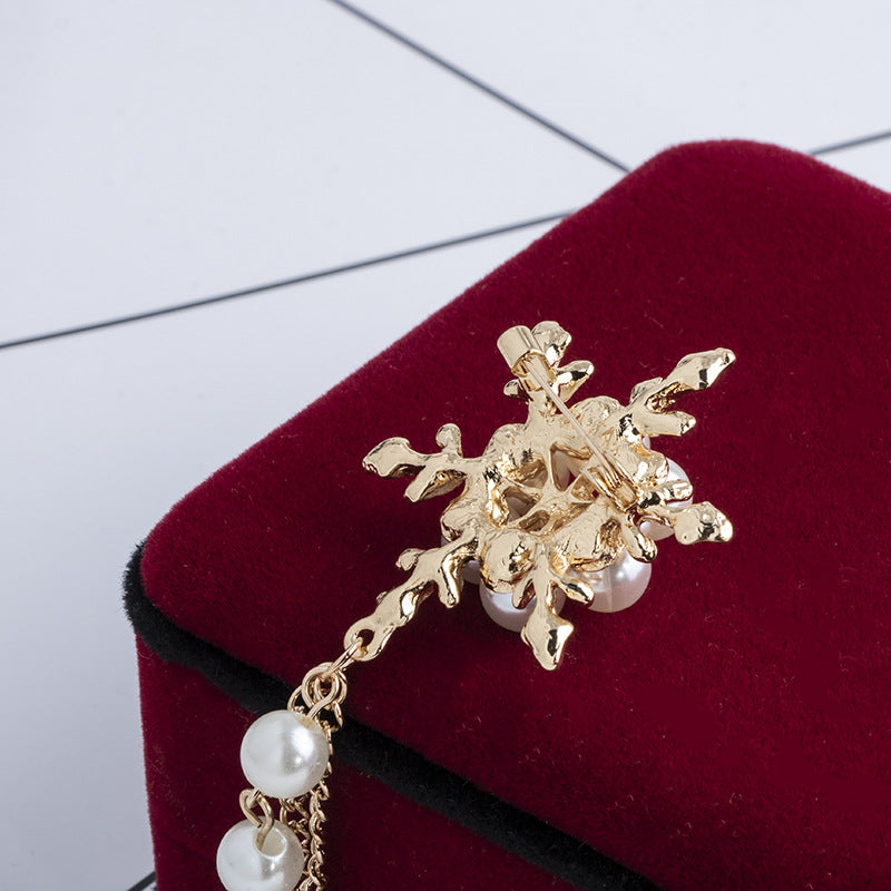 Back side of the Gold brooch with pearl accents on a red velvet surface