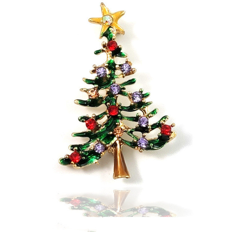Christmas tree-shaped brooch with colorful gemstones on a white background
