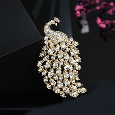 Decorative peacock brooch with crystals on a black background