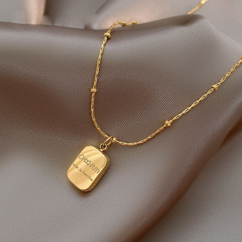 Gold necklace with a pendant on a soft fabric background