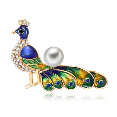 Peacock-shaped brooch with pearl and gemstones on a white background