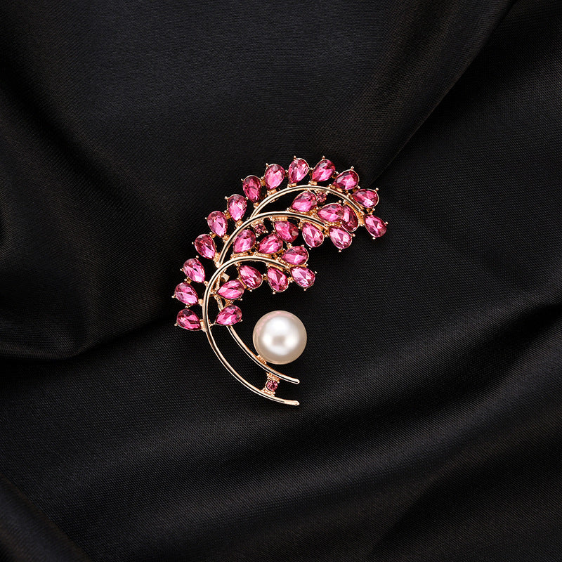 Brooch with pink gemstones and a pearl on black fabric