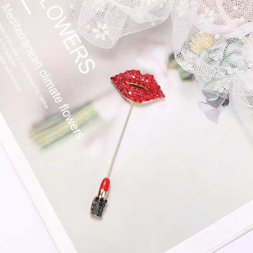 Red lip-shaped brooch on a magazine with flowers in the background
