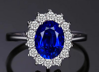 Ring with a blue gemstone and diamond-studded halo on a dark background