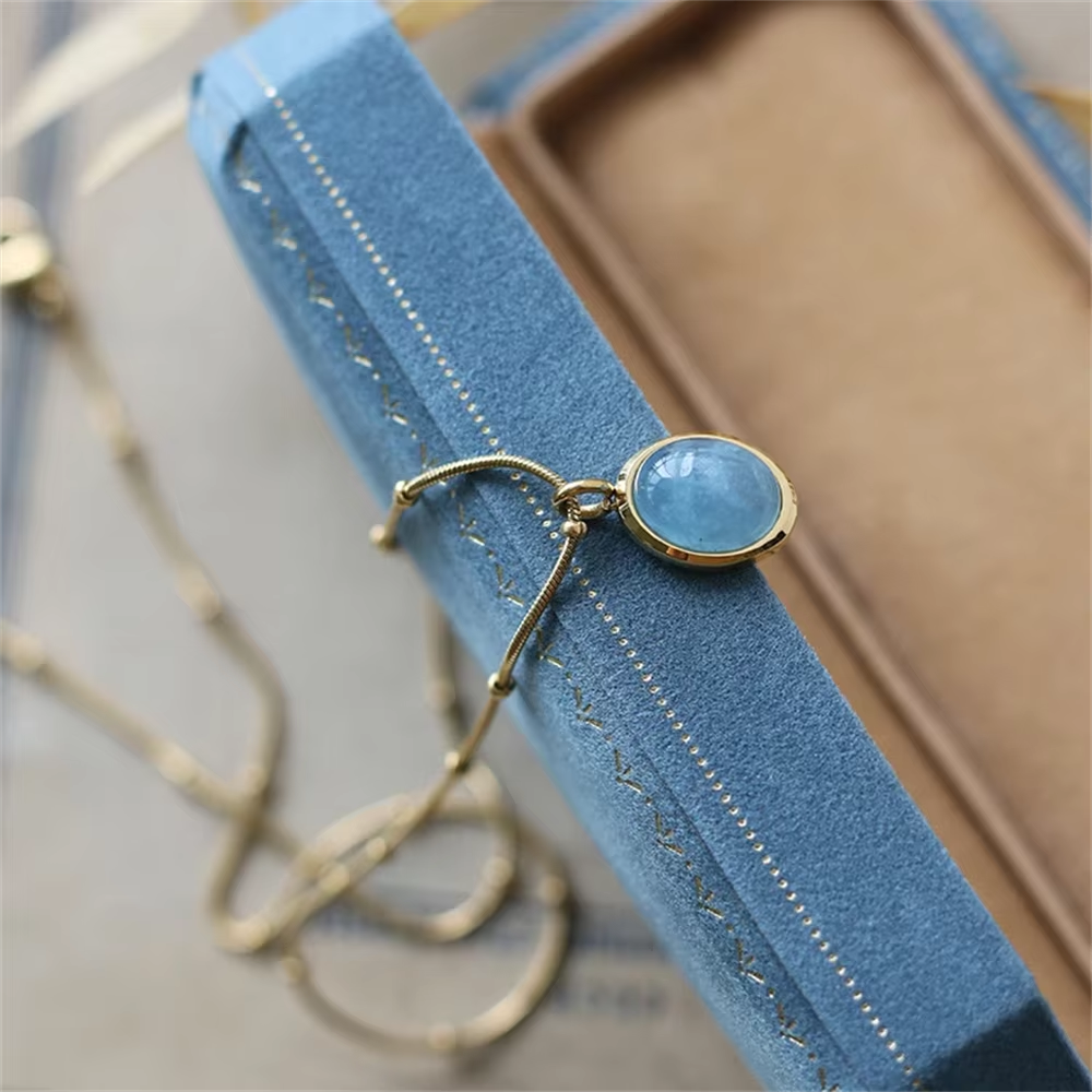 Gold bracelet with a blue gemstone on a blue stand