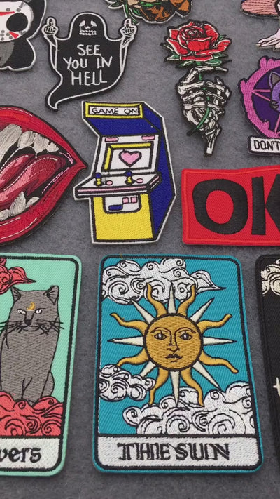video of Iron-on horror, tarot, gamer, and punk embroidered patches – colorful edgy designs on grey background